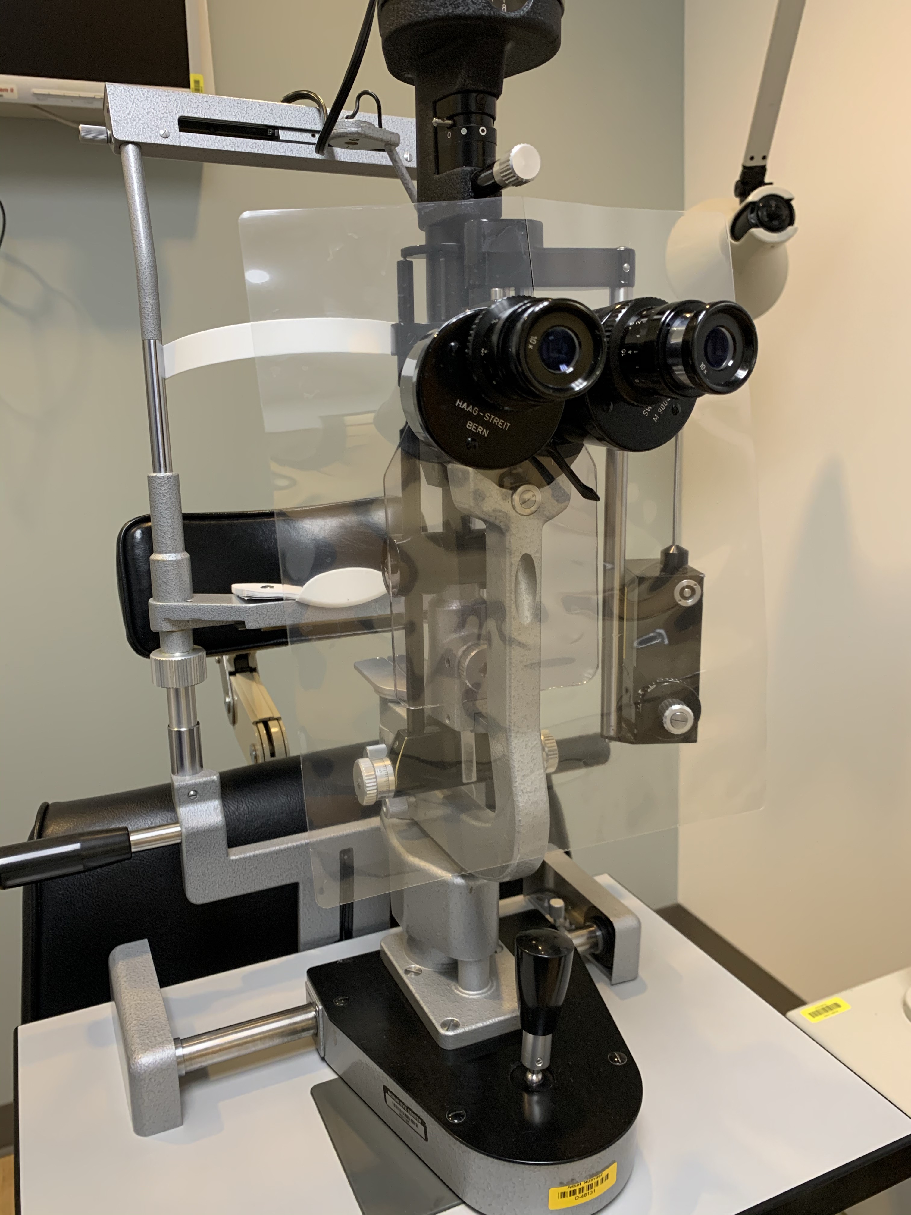 A slit-lamp shield to protect the examiner as designed by Moran Technicians Stein Erickson, Emily Petersen and Anna Reed together with help from others: made by passing two lamination sheets together through a laminator without anything inbetween